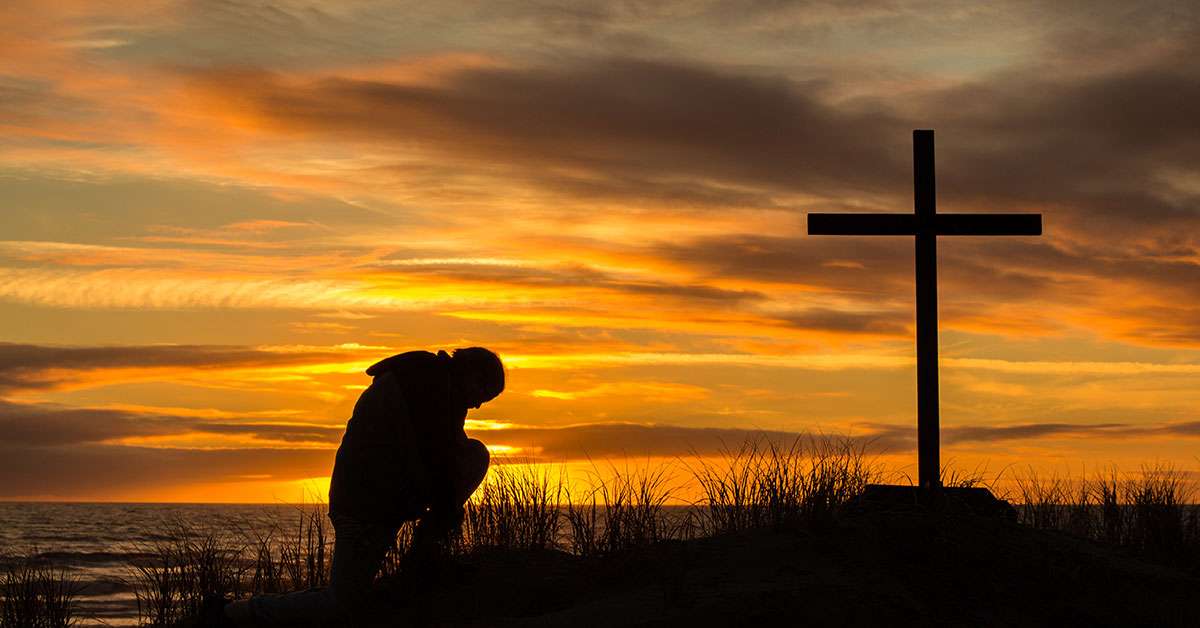 Man bowing down before the Cross